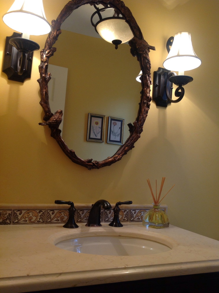 Cette image montre une salle de bain traditionnelle en bois foncé avec un plan de toilette en calcaire, un carrelage multicolore, des carreaux en terre cuite, WC séparés, un lavabo encastré, un mur jaune, tomettes au sol et un placard en trompe-l'oeil.