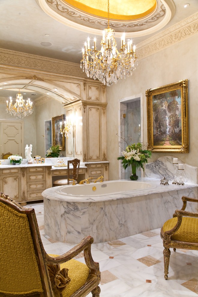 На фото: огромная главная ванная комната в средиземноморском стиле с бежевыми фасадами, накладной ванной, бежевой плиткой, бежевыми стенами и фасадами с утопленной филенкой с
