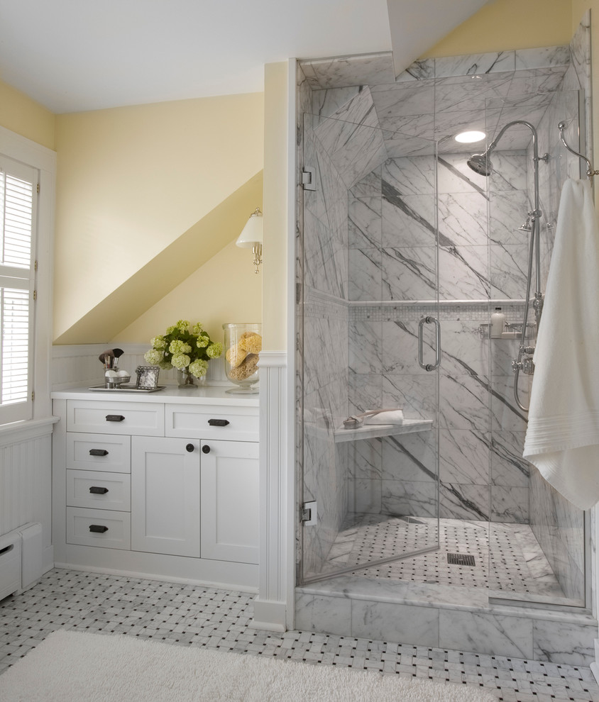 Modelo de cuarto de baño tradicional con armarios estilo shaker, puertas de armario blancas, ducha empotrada, baldosas y/o azulejos blancos, paredes amarillas y suelo con mosaicos de baldosas