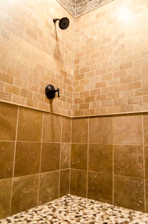 Immagine di una grande stanza da bagno padronale tradizionale con doccia alcova, piastrelle di ciottoli, lavabo sottopiano e piastrelle beige