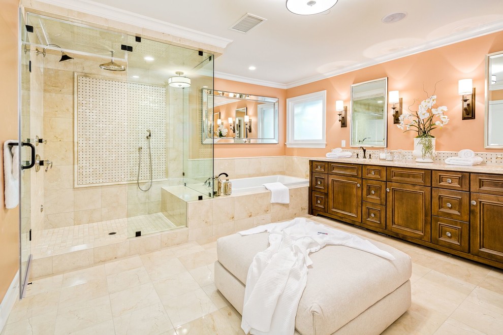 На фото: большая главная ванная комната в классическом стиле с фасадами с утопленной филенкой, темными деревянными фасадами, накладной ванной, душем в нише, бежевой плиткой, плиткой из известняка, розовыми стенами, полом из известняка, врезной раковиной, столешницей из известняка, бежевым полом и душем с распашными дверями с