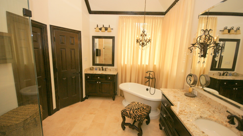 Example of a classic beige tile and stone tile bathroom design in Dallas with an undermount sink, furniture-like cabinets, dark wood cabinets, granite countertops and a two-piece toilet