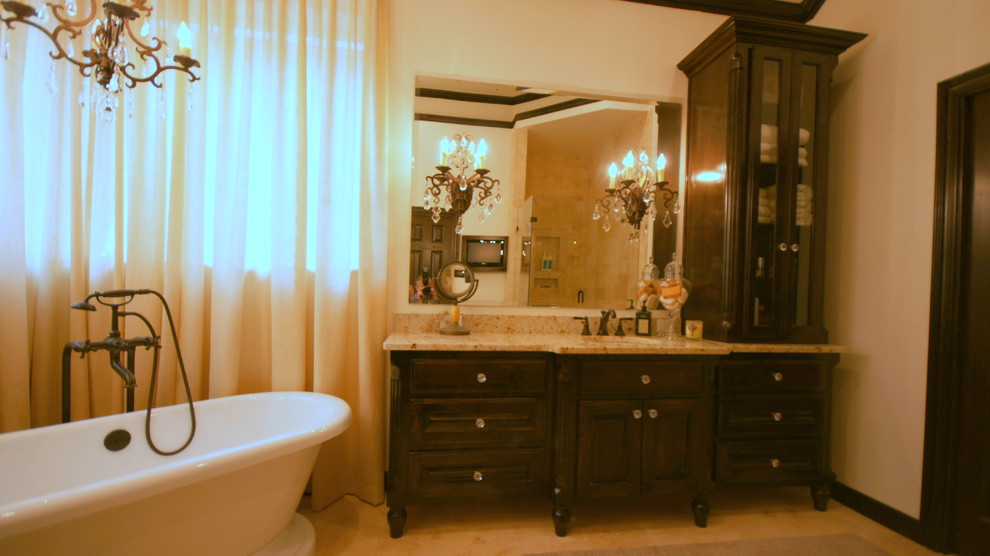 Design ideas for a traditional bathroom in Dallas with a submerged sink, freestanding cabinets, dark wood cabinets, granite worktops, a freestanding bath, a corner shower, a two-piece toilet, beige tiles and stone tiles.