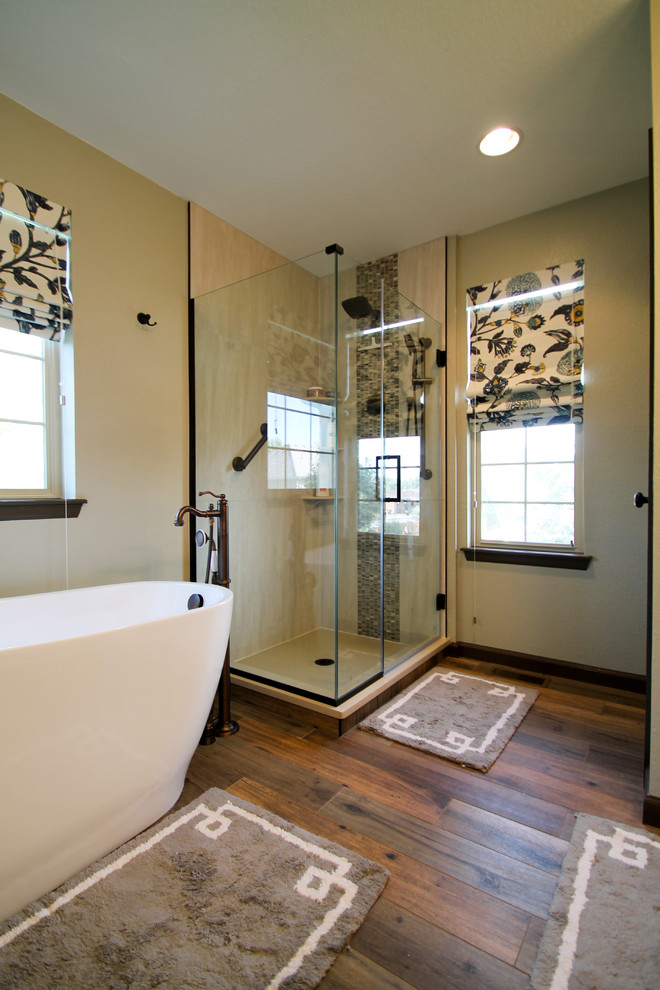Medium sized traditional ensuite bathroom in Denver with raised-panel cabinets, light wood cabinets, a freestanding bath, a corner shower, a one-piece toilet, beige tiles, porcelain tiles, green walls, porcelain flooring, a submerged sink, granite worktops, brown floors and a hinged door.