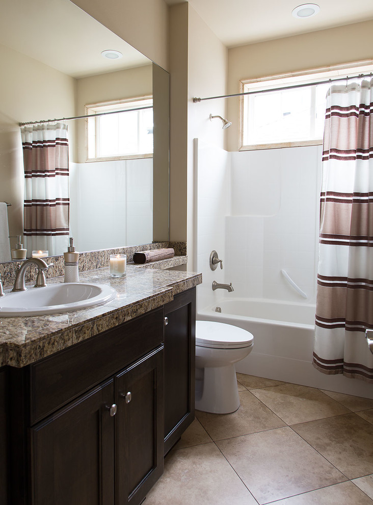 Example of a mid-sized classic kids' beige tile bathroom design in Seattle with a drop-in sink, recessed-panel cabinets, granite countertops, a two-piece toilet and beige walls