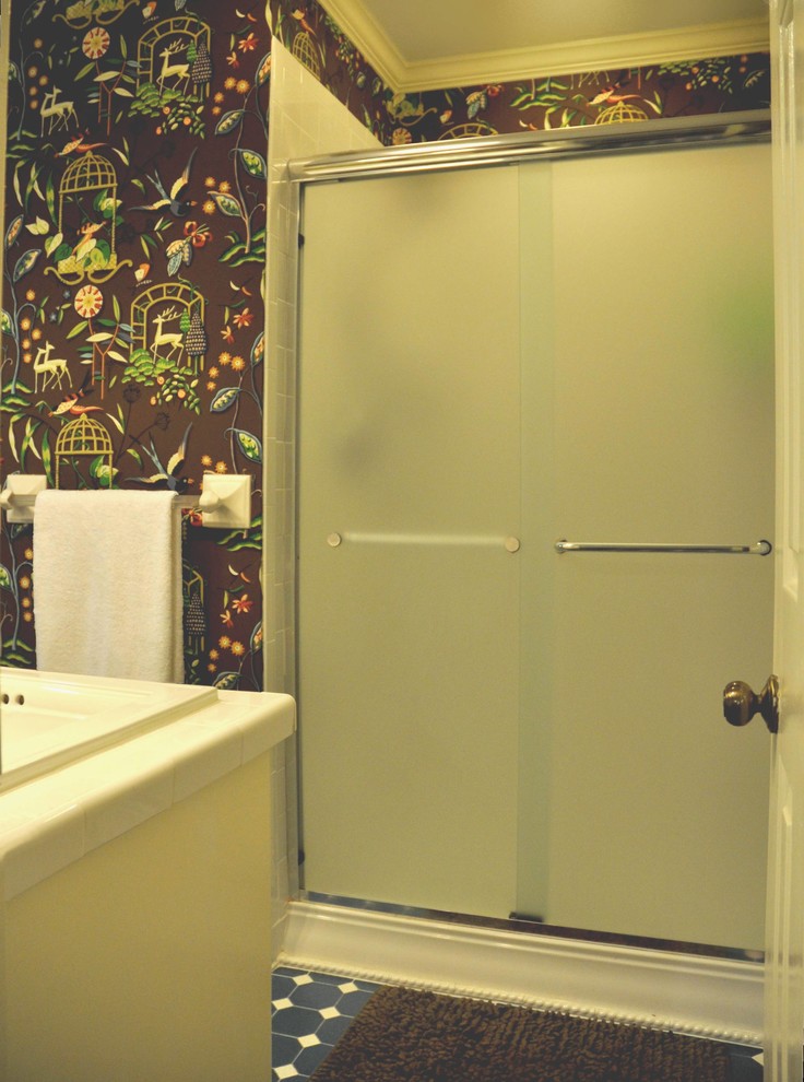 Modelo de cuarto de baño ecléctico con lavabo encastrado, puertas de armario blancas, encimera de azulejos, ducha empotrada y sanitario de una pieza