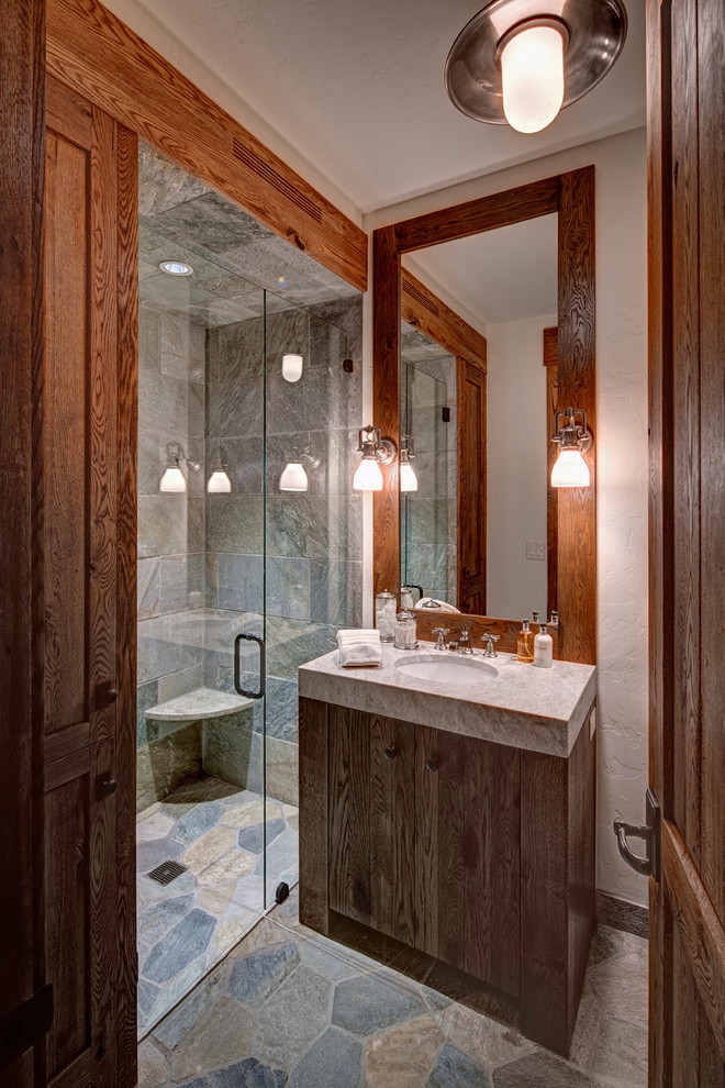 Inspiration for a rustic shower room bathroom in San Francisco with an alcove shower, flat-panel cabinets, dark wood cabinets, multi-coloured tiles, stone tiles, white walls, a submerged sink and limestone worktops.