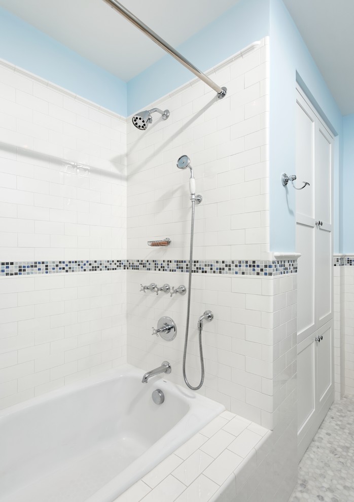 This is an example of a medium sized traditional bathroom in DC Metro with an alcove bath, a shower/bath combination, a two-piece toilet, white tiles, metro tiles, blue walls, mosaic tile flooring and a pedestal sink.