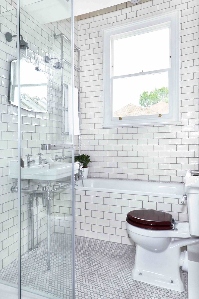 Foto di una piccola stanza da bagno per bambini classica con vasca da incasso, doccia ad angolo, WC a due pezzi, piastrelle bianche, piastrelle in ceramica, pareti bianche, pavimento con piastrelle a mosaico e lavabo a colonna