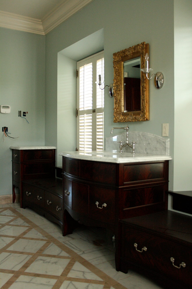 Пример оригинального дизайна: главная ванная комната среднего размера в классическом стиле с плоскими фасадами, темными деревянными фасадами, отдельно стоящей ванной, белой плиткой, мраморной плиткой, серыми стенами, мраморным полом, врезной раковиной, мраморной столешницей, белым полом и белой столешницей