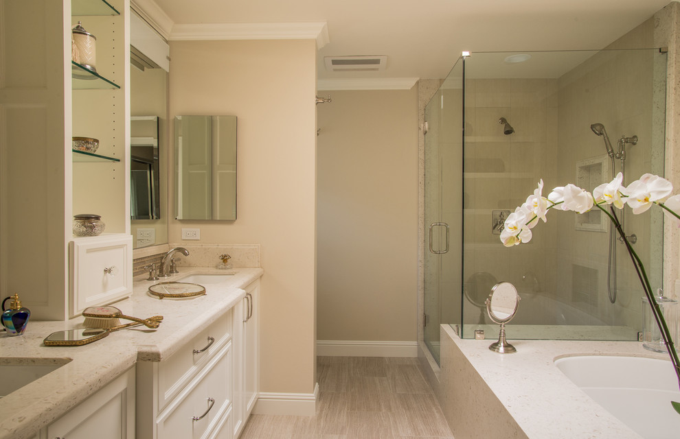 ロサンゼルスにある高級な中くらいなトランジショナルスタイルのおしゃれなマスターバスルーム (落し込みパネル扉のキャビネット、白いキャビネット、アンダーマウント型浴槽、コーナー設置型シャワー、分離型トイレ、ベージュのタイル、グレーのタイル、ボーダータイル、ベージュの壁、リノリウムの床、アンダーカウンター洗面器、クオーツストーンの洗面台) の写真
