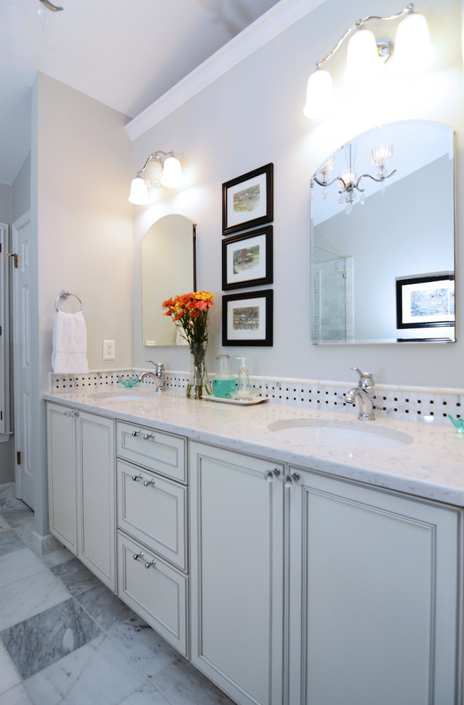 На фото: ванная комната в классическом стиле с врезной раковиной, фасадами с утопленной филенкой, белыми фасадами, столешницей из искусственного кварца, полновстраиваемой ванной, открытым душем и разноцветной плиткой с