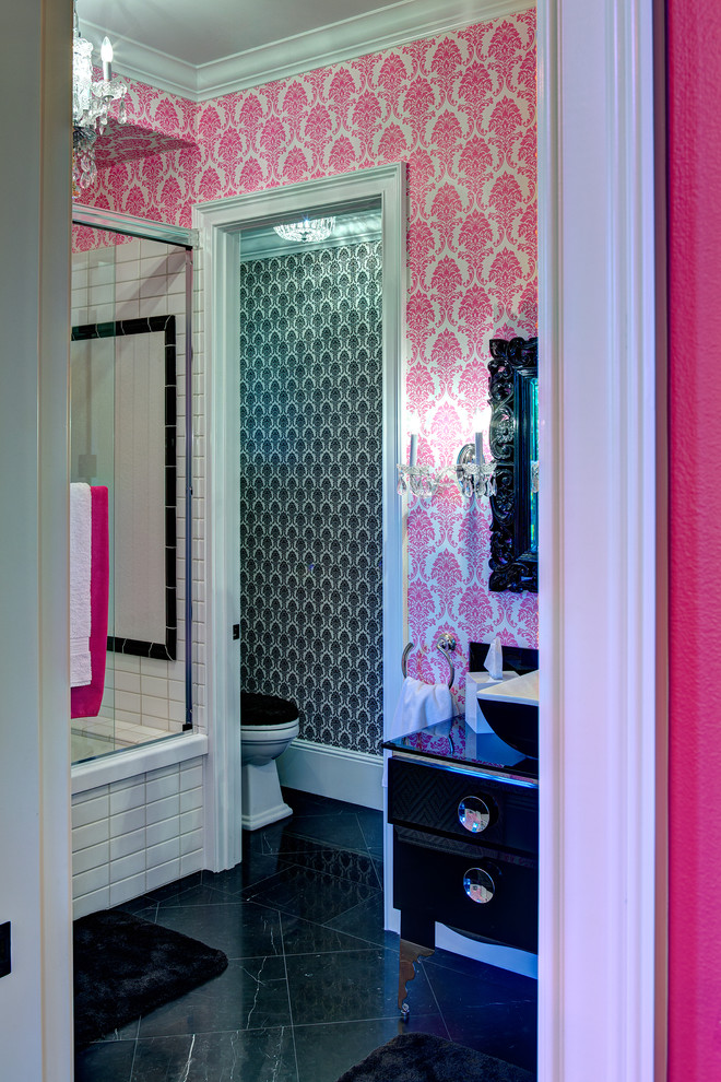 Cette photo montre une salle de bain chic de taille moyenne pour enfant avec des portes de placard noires, une baignoire en alcôve, un combiné douche/baignoire, WC séparés, un carrelage noir et blanc, des carreaux de céramique, un mur rose, un sol en marbre, une vasque, un plan de toilette en verre, un placard en trompe-l'oeil, un sol noir, une cabine de douche à porte coulissante et un plan de toilette noir.