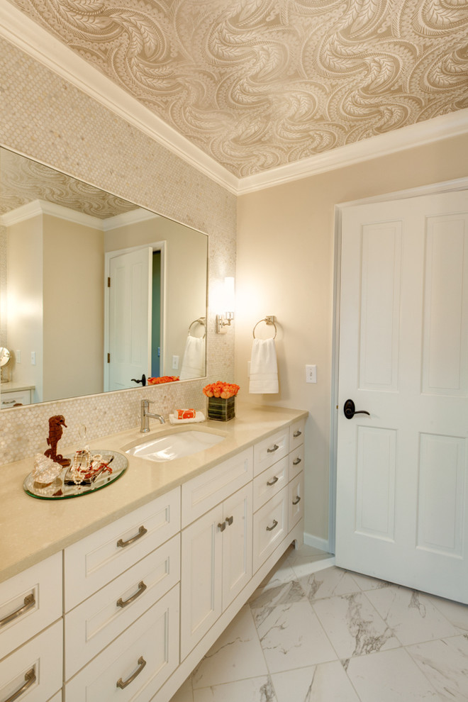 Inspiration pour une salle de bain traditionnelle avec un placard avec porte à panneau encastré, des portes de placard blanches, un carrelage blanc, mosaïque, un mur beige, un sol en marbre, un lavabo encastré et un plan de toilette en quartz modifié.