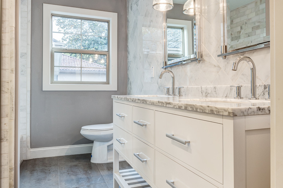Inspiration for a medium sized classic family bathroom in Sacramento with a submerged sink, flat-panel cabinets, white cabinets, marble worktops, a one-piece toilet, grey tiles, mosaic tiles, grey walls and porcelain flooring.