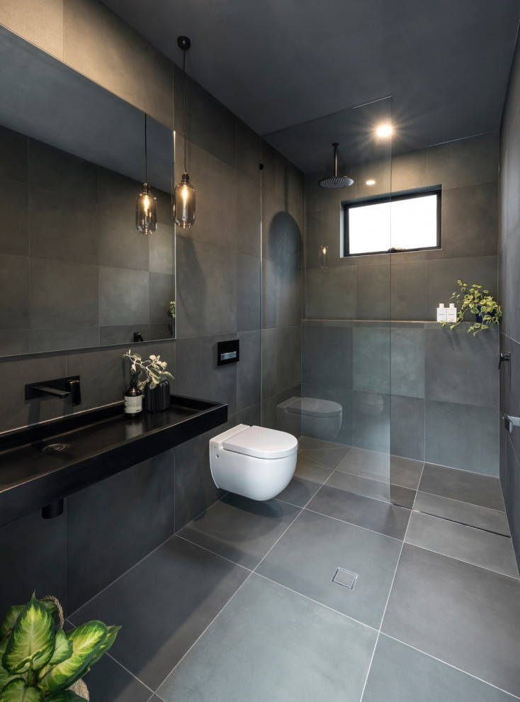 Inredning av ett modernt en-suite badrum, med en öppen dusch, en vägghängd toalettstol, grå kakel, keramikplattor, klinkergolv i keramik, grått golv och med dusch som är öppen