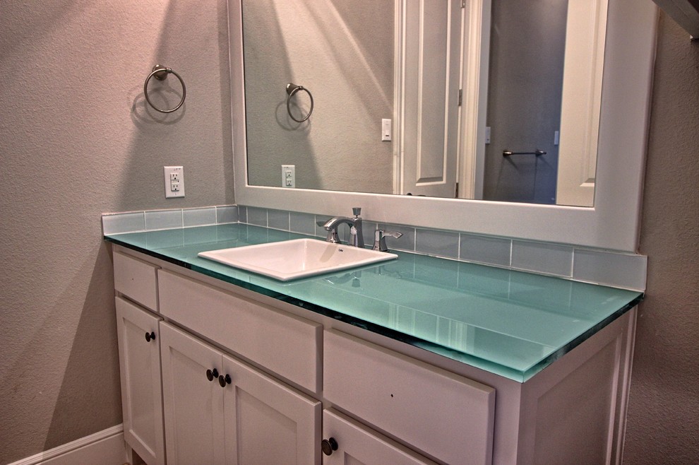 Photo of a medium sized traditional shower room bathroom in Dallas with shaker cabinets, white cabinets, blue tiles, glass tiles, grey walls, a built-in sink and glass worktops.