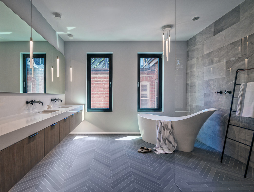 Идея дизайна: главная ванная комната в современном стиле с плоскими фасадами, темными деревянными фасадами, отдельно стоящей ванной, серой плиткой, серыми стенами, врезной раковиной и серым полом
