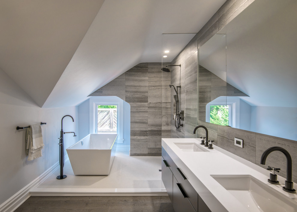 Inredning av ett modernt en-suite badrum, med släta luckor, ett fristående badkar, grå kakel, en öppen dusch, grå väggar, ett undermonterad handfat, vitt golv och med dusch som är öppen