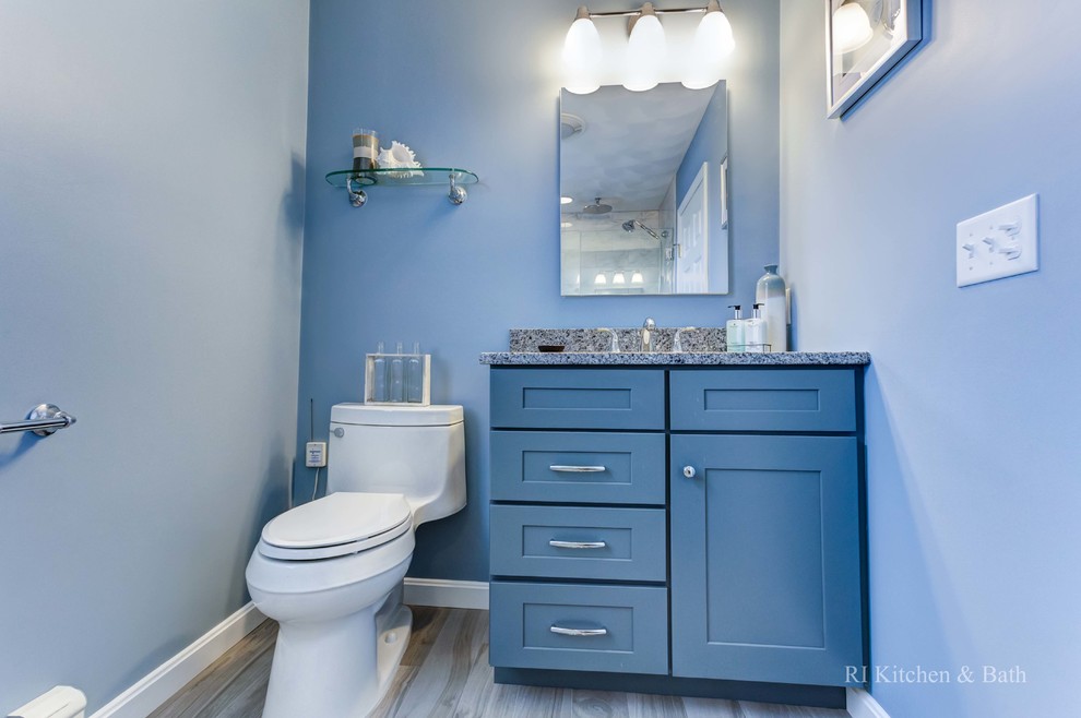 На фото: главная ванная комната среднего размера в современном стиле с врезной раковиной, фасадами в стиле шейкер, синими фасадами, столешницей из гранита, душем в нише, унитазом-моноблоком, серой плиткой, стеклянной плиткой, синими стенами и полом из керамогранита