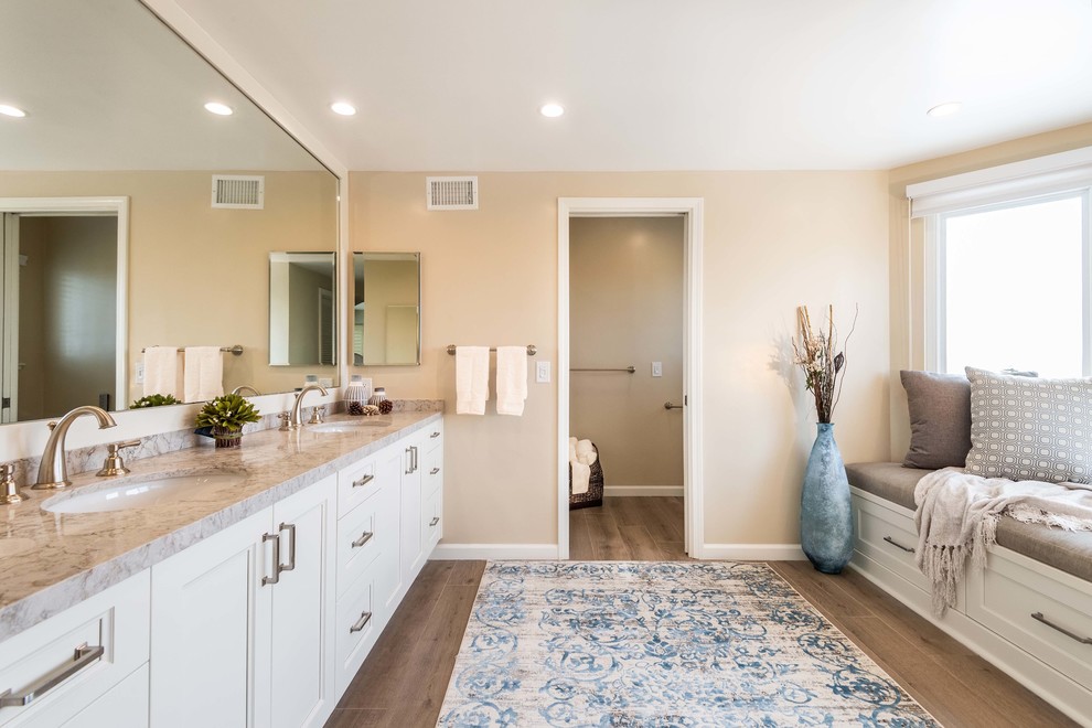 Inspiration for a transitional master brown floor bathroom remodel in Los Angeles with recessed-panel cabinets, white cabinets, beige walls, an undermount sink and beige countertops