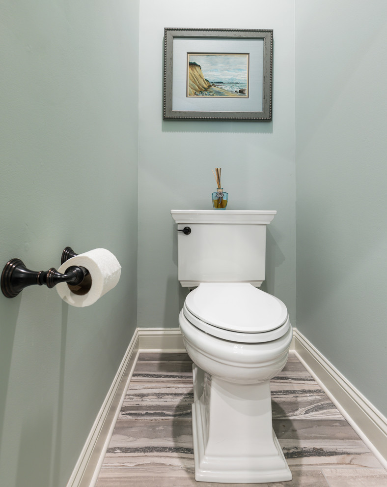 На фото: туалет в морском стиле с фасадами с утопленной филенкой, синими фасадами, раздельным унитазом, зеленой плиткой, керамогранитной плиткой, синими стенами, полом из керамогранита, врезной раковиной, столешницей из искусственного кварца, синим полом и разноцветной столешницей