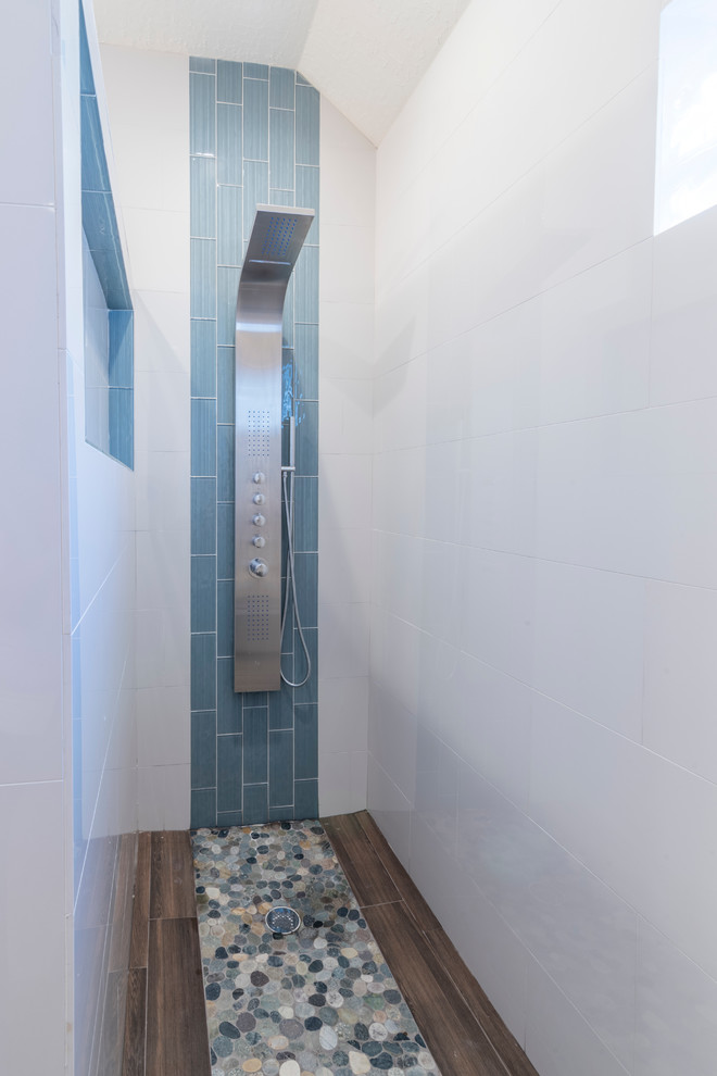 Mid-sized transitional master white tile and porcelain tile porcelain tile doorless shower photo in Houston with flat-panel cabinets, blue cabinets, a two-piece toilet, beige walls, a vessel sink and quartz countertops