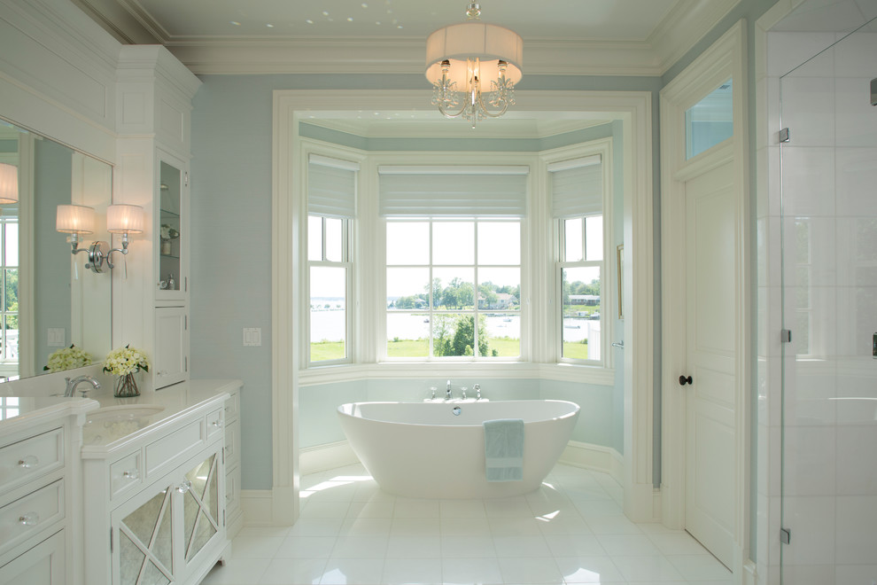 Foto de cuarto de baño clásico con puertas de armario blancas, bañera exenta, ducha empotrada, paredes azules y armarios tipo vitrina
