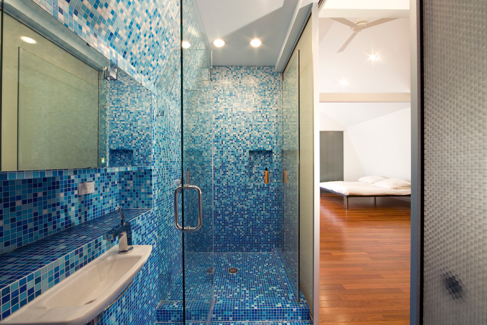 Idéer för små funkis badrum med dusch, med blå kakel, glaskakel, en dusch i en alkov, blå väggar, mosaikgolv, ett väggmonterat handfat, blått golv och dusch med gångjärnsdörr