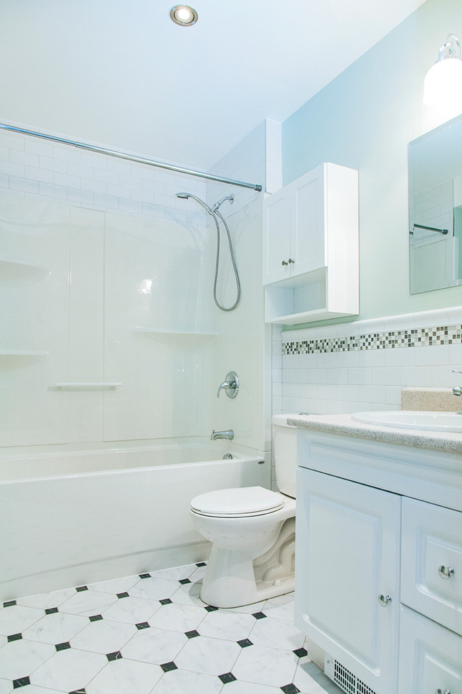 Esempio di una piccola stanza da bagno moderna con ante bianche, vasca ad alcova, vasca/doccia, WC a due pezzi, piastrelle in ceramica, pareti verdi, pavimento con piastrelle in ceramica, lavabo a consolle e top in laminato
