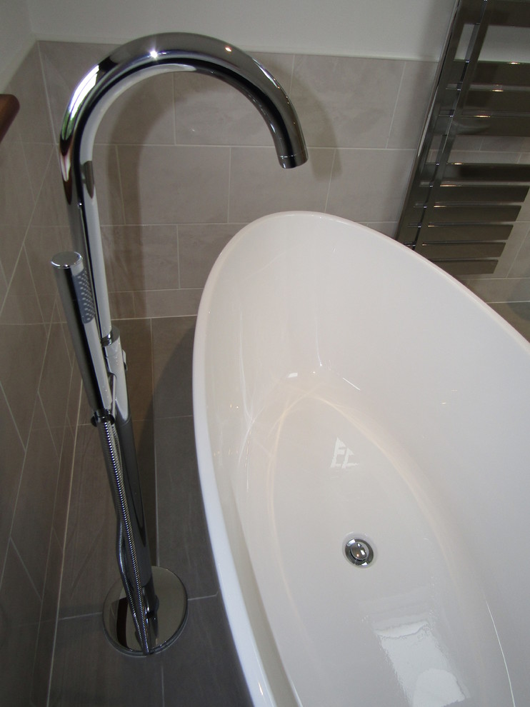 Immagine di una stanza da bagno per bambini minimal con vasca freestanding, vasca/doccia, piastrelle grigie, piastrelle in ceramica, pavimento con piastrelle in ceramica e pavimento grigio