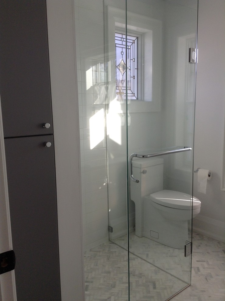 Идея дизайна: ванная комната в стиле модернизм с плоскими фасадами, серыми фасадами, унитазом-моноблоком, белой плиткой, белыми стенами, мраморным полом, врезной раковиной, столешницей из искусственного кварца, душем без бортиков, керамической плиткой, душевой кабиной, душем с распашными дверями и белой столешницей