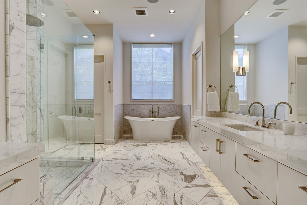Klassisk inredning av ett vit vitt en-suite badrum, med släta luckor, vita skåp, ett fristående badkar, en hörndusch, vita väggar, ett undermonterad handfat, vitt golv och dusch med gångjärnsdörr