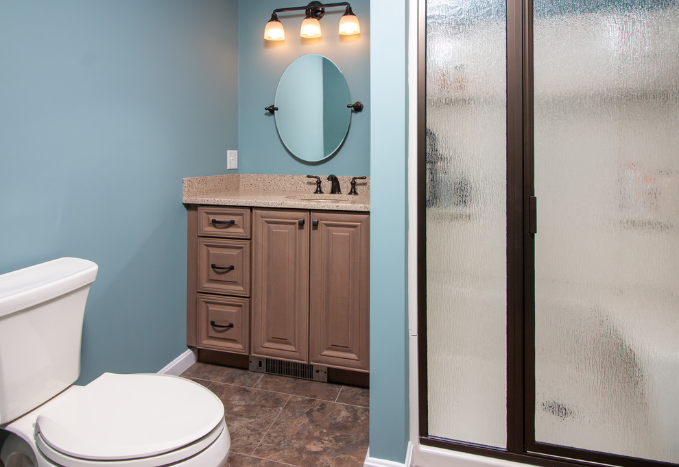 Пример оригинального дизайна: ванная комната среднего размера в стиле неоклассика (современная классика) с фасадами с выступающей филенкой, коричневыми фасадами, душем в нише, раздельным унитазом, синими стенами, полом из винила, душевой кабиной, врезной раковиной, столешницей из искусственного кварца, коричневым полом, душем с распашными дверями и бежевой столешницей