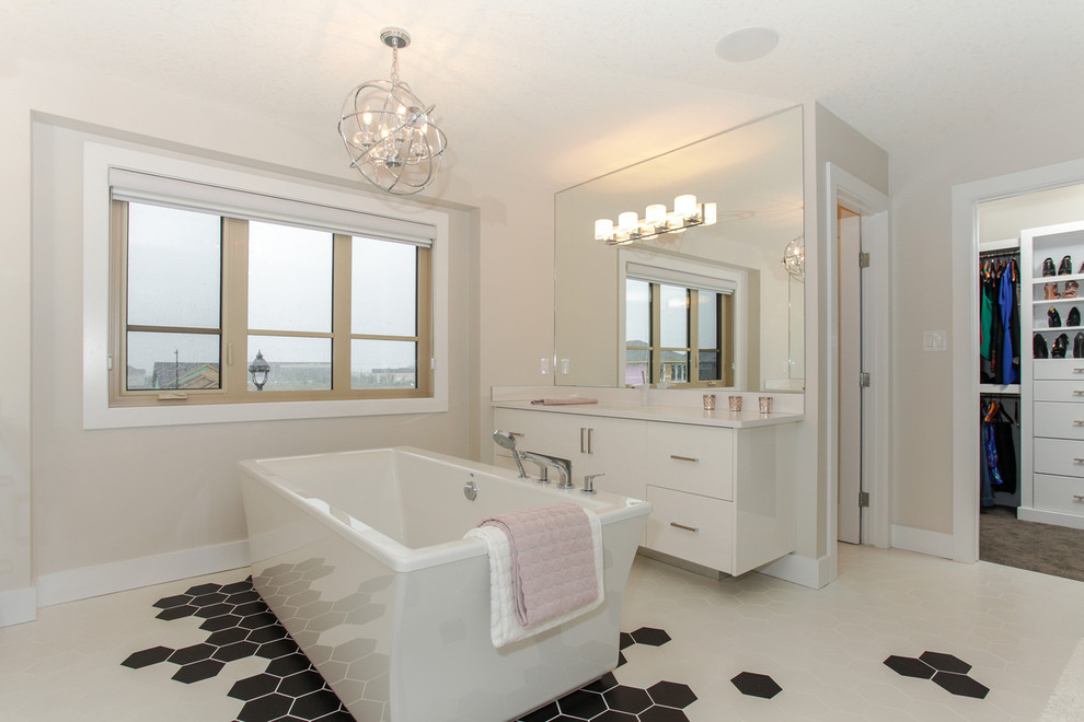 Ejemplo de cuarto de baño actual con armarios con paneles lisos, puertas de armario blancas, bañera exenta, paredes beige y vestidor