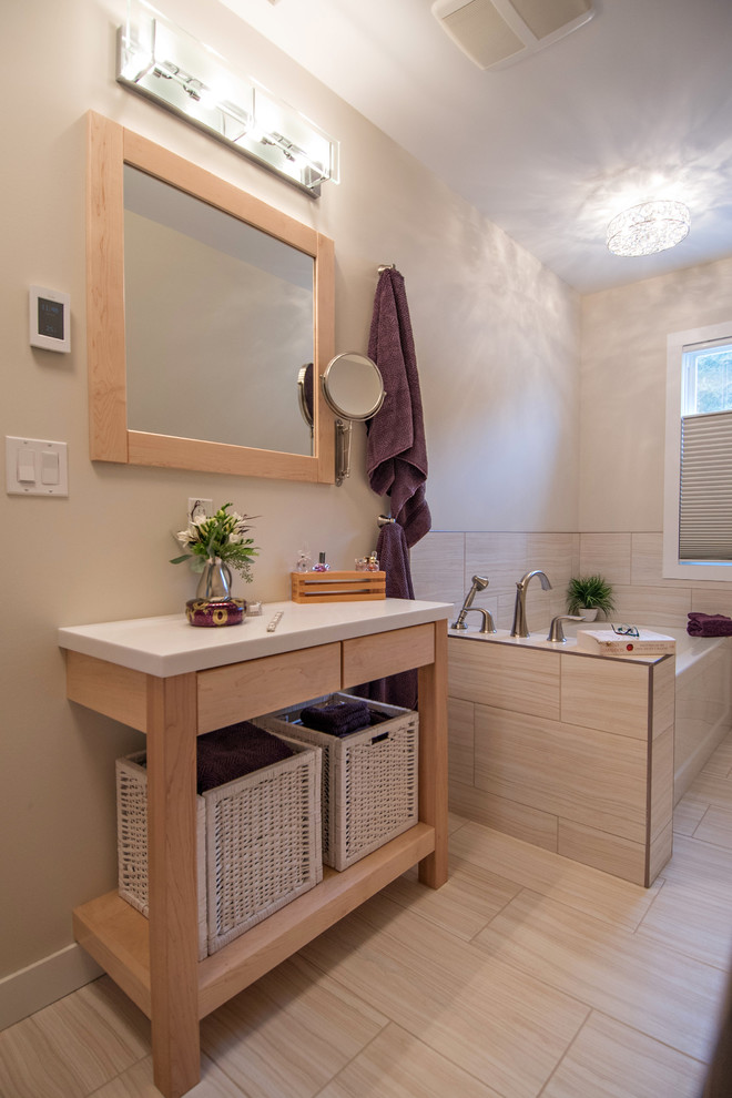 Cette image montre une petite salle de bain principale traditionnelle avec un placard à porte plane, des portes de placard blanches, un plan de toilette en surface solide, des carreaux de porcelaine, une baignoire d'angle, WC séparés, un mur beige, un sol en vinyl et un lavabo encastré.