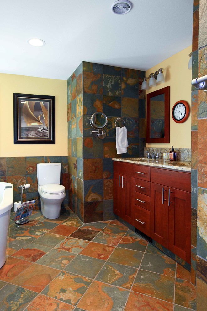 Idéer för ett mellanstort klassiskt en-suite badrum, med ett undermonterad handfat, skåp i shakerstil, skåp i mellenmörkt trä, granitbänkskiva, ett fristående badkar, en hörndusch, en toalettstol med separat cisternkåpa, flerfärgad kakel, stenkakel, gula väggar och skiffergolv