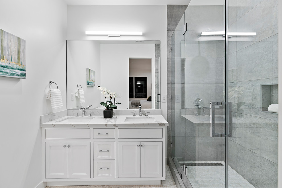 サンフランシスコにある高級な広いトランジショナルスタイルのおしゃれな浴室 (落し込みパネル扉のキャビネット、白いキャビネット、ダブルシャワー、グレーのタイル、セラミックタイル、白い壁、セラミックタイルの床、アンダーカウンター洗面器、珪岩の洗面台、開き戸のシャワー、白い洗面カウンター、ベージュの床) の写真