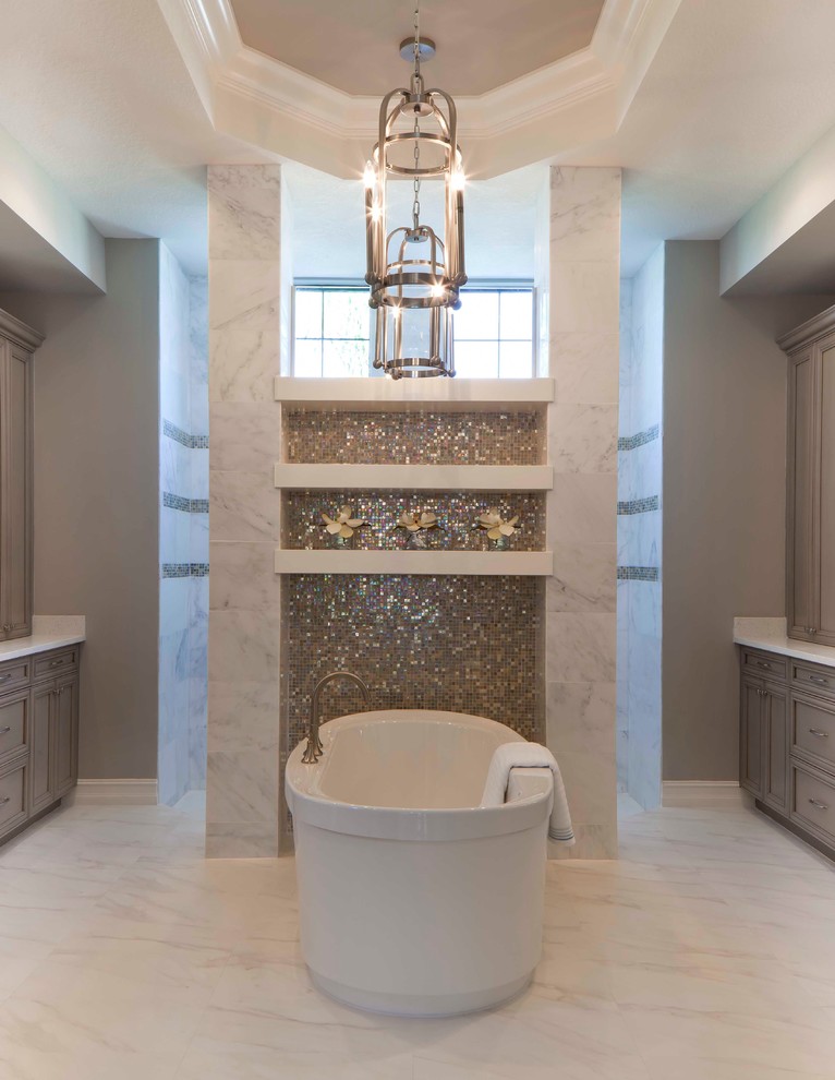 Inspiration for an expansive classic ensuite bathroom in Miami with recessed-panel cabinets, a freestanding bath, multi-coloured tiles, grey walls and grey cabinets.