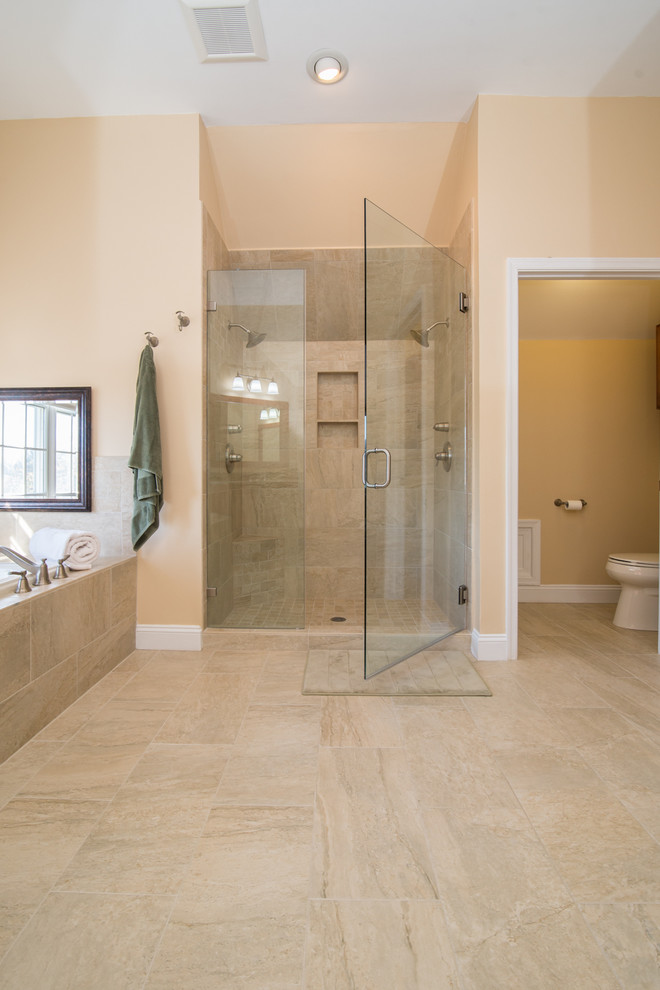 Design ideas for a large traditional ensuite bathroom in DC Metro with a submerged sink, raised-panel cabinets, medium wood cabinets, granite worktops, a built-in bath, an alcove shower, a two-piece toilet, beige tiles, porcelain tiles, beige walls and porcelain flooring.