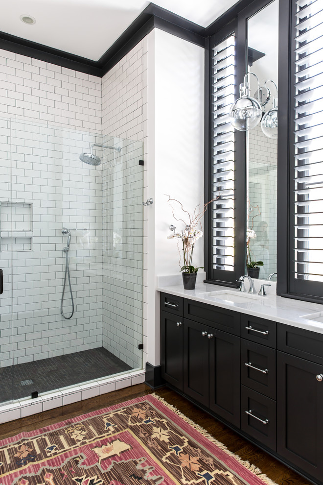 チャールストンにあるトランジショナルスタイルのおしゃれな浴室 (シェーカースタイル扉のキャビネット、黒いキャビネット、アルコーブ型シャワー、白いタイル、サブウェイタイル、白い壁、アンダーカウンター洗面器、開き戸のシャワー) の写真
