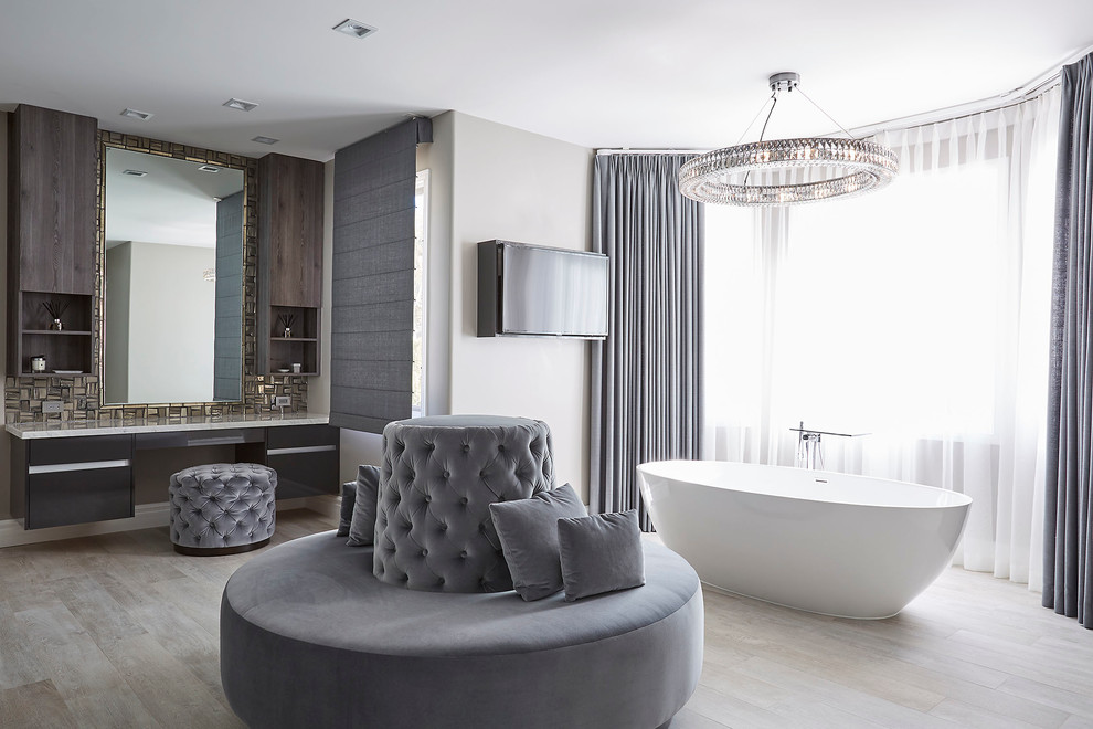 Foto di una stanza da bagno padronale chic con ante lisce, vasca freestanding, pareti grigie e parquet chiaro