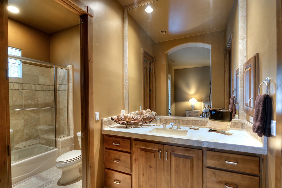 Стильный дизайн: ванная комната среднего размера в стиле неоклассика (современная классика) с каменной плиткой, врезной раковиной, фасадами цвета дерева среднего тона, душем над ванной и унитазом-моноблоком - последний тренд