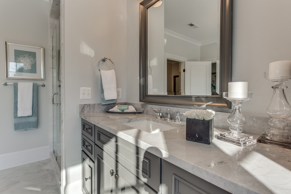 ワシントンD.C.にあるトランジショナルスタイルのおしゃれな浴室 (グレーのキャビネット、置き型浴槽、アンダーカウンター洗面器、大理石の洗面台) の写真