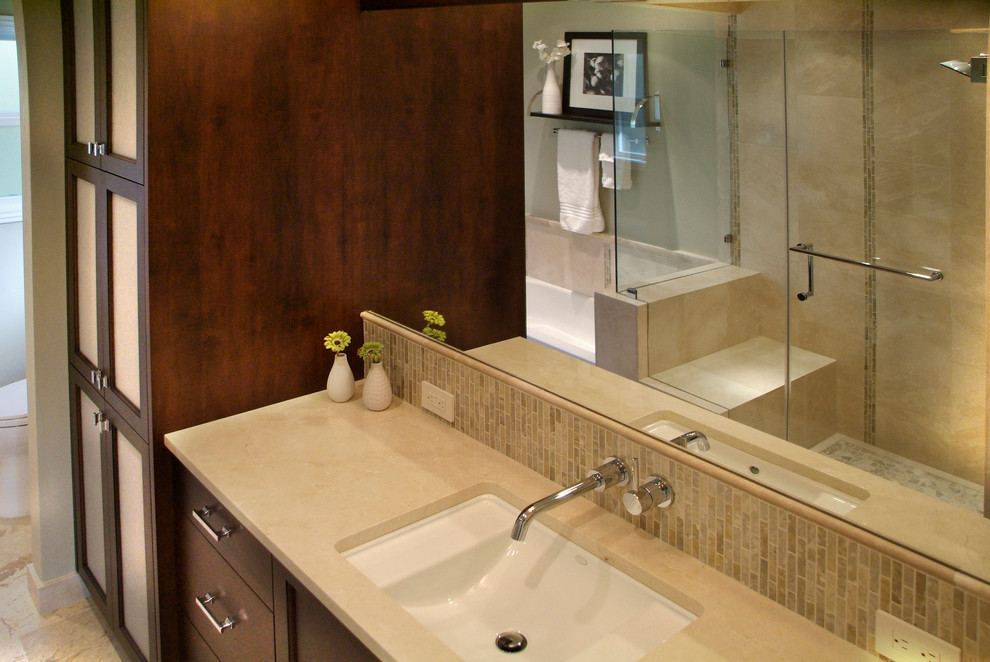Classic ensuite bathroom in Sacramento with dark wood cabinets, a corner bath, a walk-in shower, a one-piece toilet, beige walls, a built-in sink and limestone worktops.