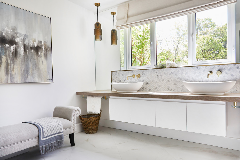Inspiration for a medium sized traditional ensuite bathroom in Cardiff with flat-panel cabinets, white cabinets, an alcove shower, a bidet, white tiles, marble tiles, white walls, ceramic flooring, wooden worktops, white floors, a sliding door, brown worktops, double sinks, a floating vanity unit and a vessel sink.