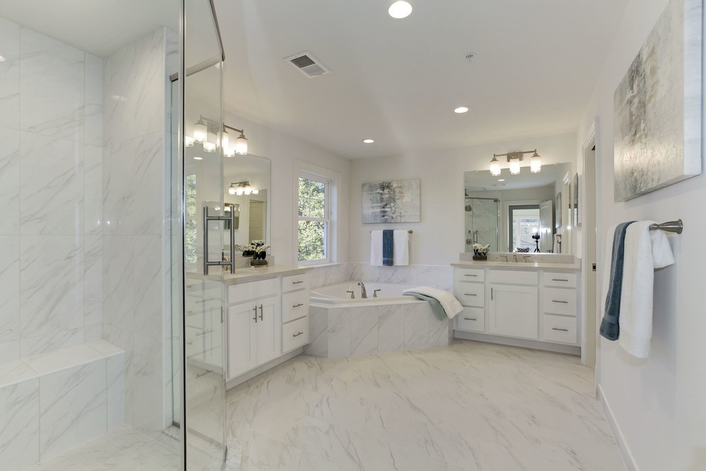 Cette image montre une salle de bain principale traditionnelle de taille moyenne avec un placard à porte shaker, une baignoire d'angle, un carrelage blanc, des carreaux de porcelaine, un mur blanc et un plan de toilette en quartz modifié.