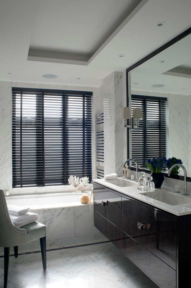 Immagine di una stanza da bagno classica con ante lisce, ante in legno bruno, vasca sottopiano, pareti multicolore e lavabo integrato