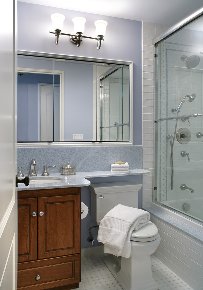 Inspiration för mellanstora klassiska badrum med dusch, med luckor med upphöjd panel, skåp i mellenmörkt trä, ett badkar i en alkov, en dusch/badkar-kombination, en toalettstol med hel cisternkåpa, vit kakel, keramikplattor, blå väggar, klinkergolv i porslin, ett undermonterad handfat och bänkskiva i kvarts