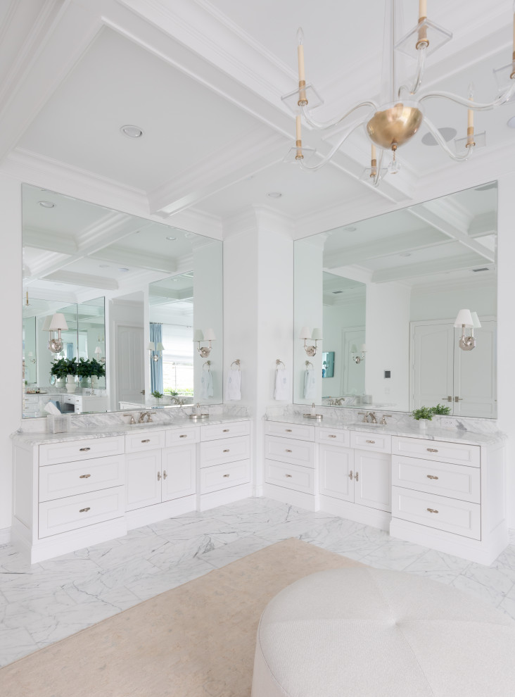 На фото: большая главная ванная комната в стиле неоклассика (современная классика) с фасадами с утопленной филенкой, белыми фасадами, белыми стенами, мраморным полом, мраморной столешницей, белым полом и белой столешницей